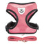 Pink dog harness with black straps and a matching leash on a white background